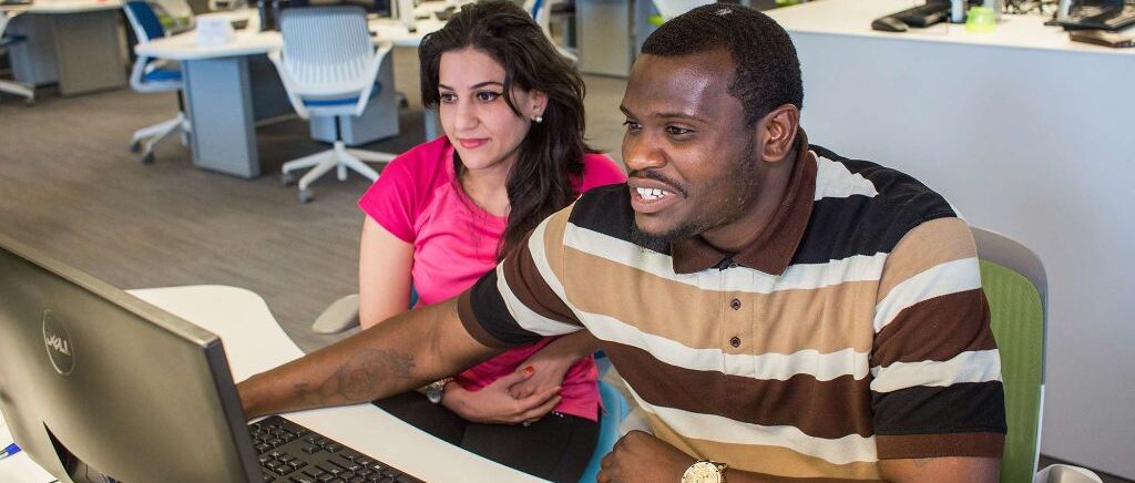 A male student and female student view a computer screen.