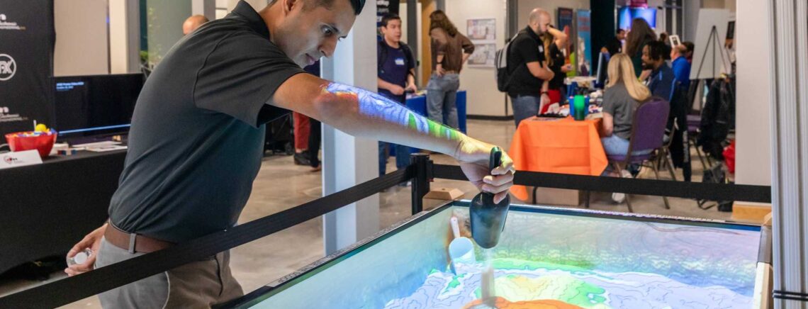 An ACC student demonstrates the "Topobiox" Real-time computer generated terrain mapping display