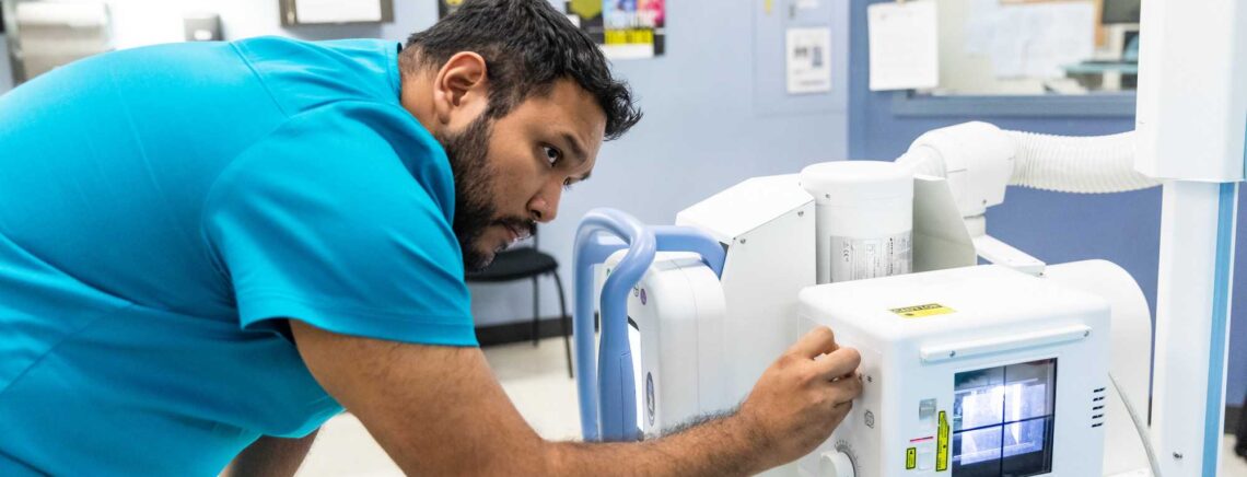 An ACC student practices using a Radiology device during ACC Radiology lab