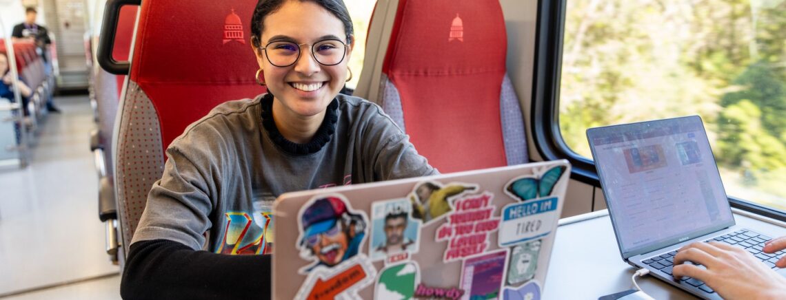 An ACC online student completes school work while riding on an Austin CapMetro train.