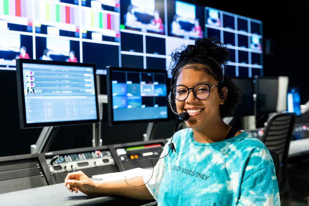 An ACC student works with broadcasting equipment inside of ACC Highland's studios.