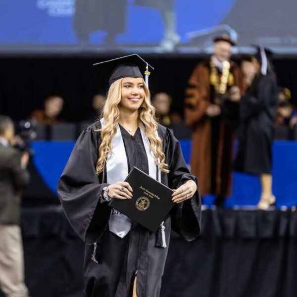 ACC Student walking down the aisle during commencement.