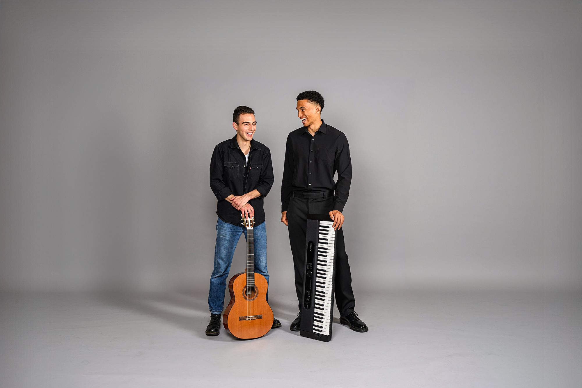 Two ACC music program students posing for a portrait with their instruments.  A guitar and a keyboard.